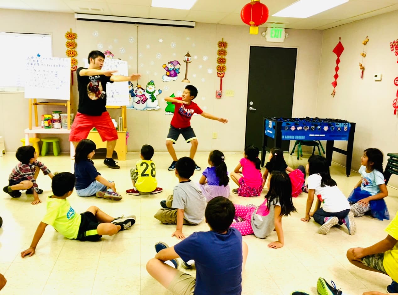 老师和学生带领孩子们做肢体活动。